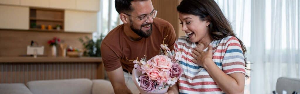 A Man Giving His Wife A Bouquet Of Flowers On Their Anniversary