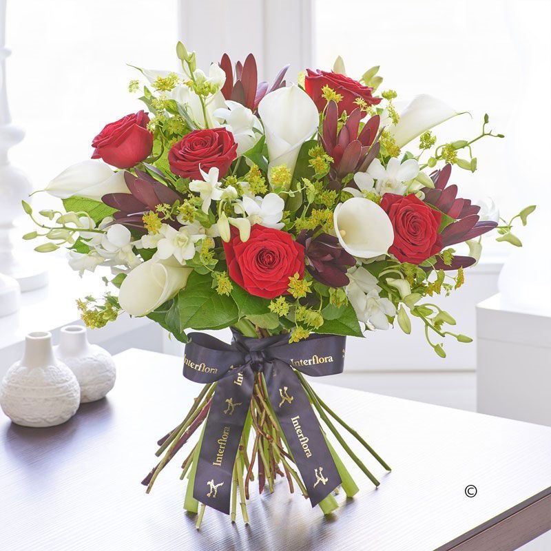Birthday bouquet of red roses and white calla lilies tied with an elegant Interflora bow