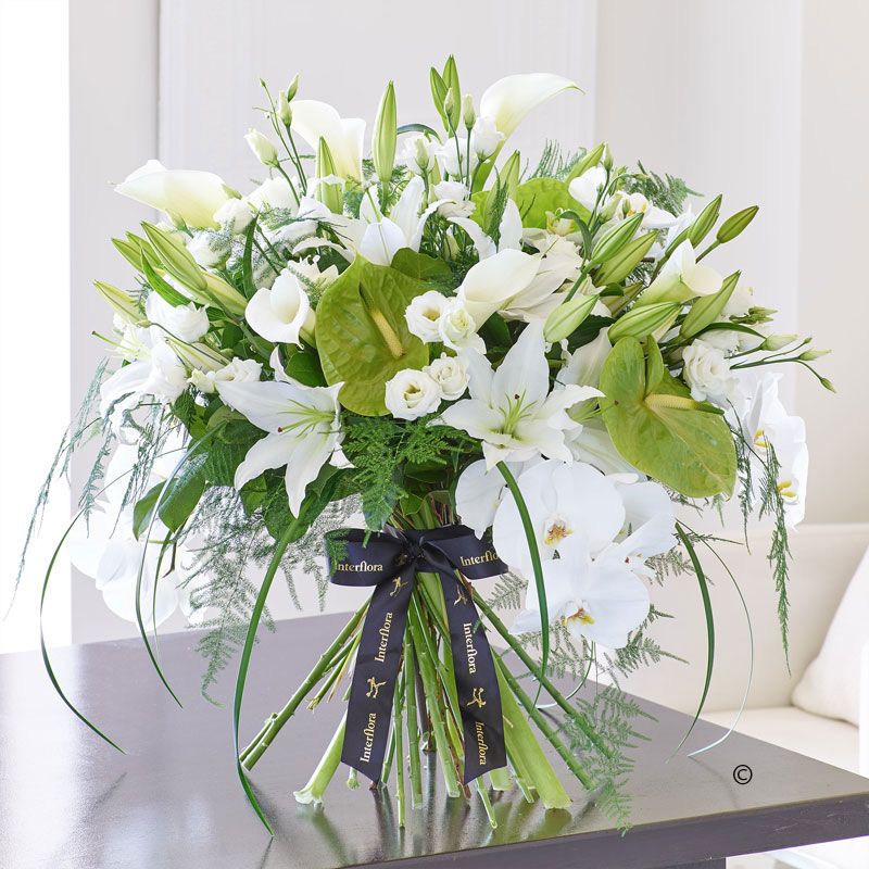Hand-tied bouquet of white lilies and fresh green foliage